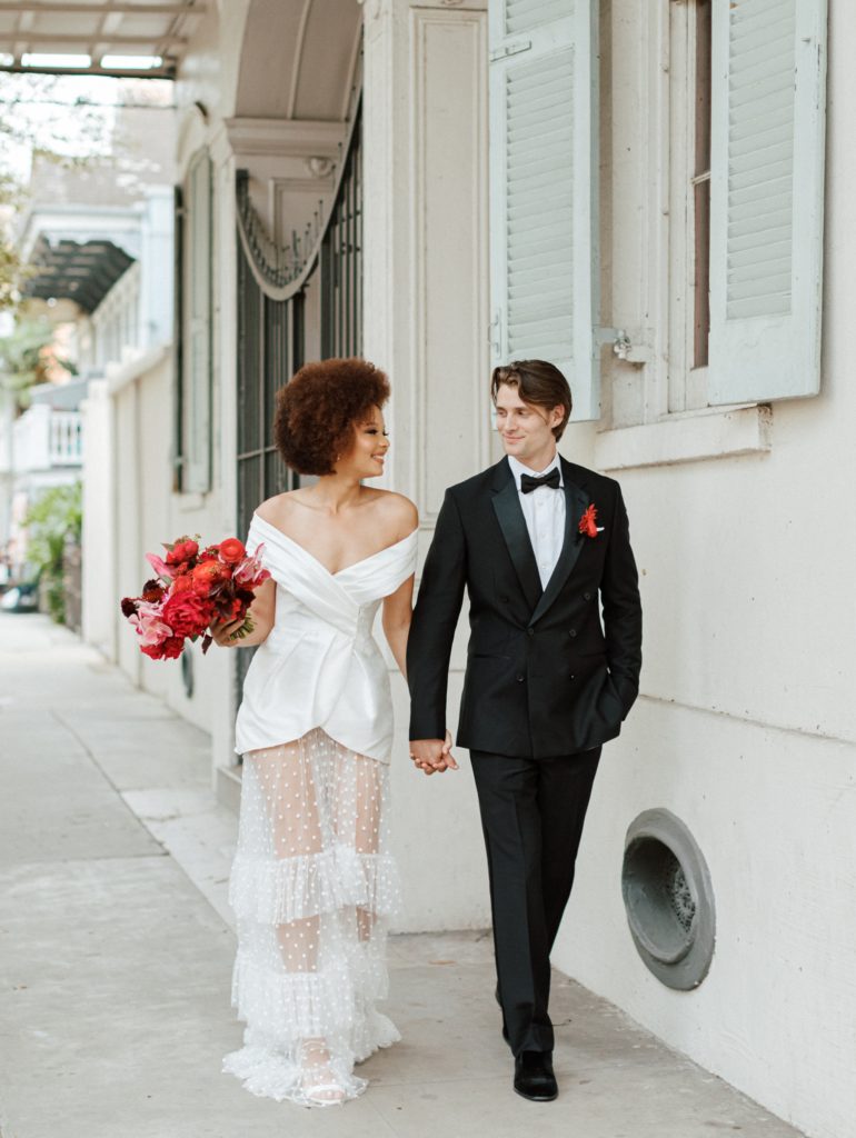 Bride and groom walking hand in hand in the French Quarter on their wedding day.